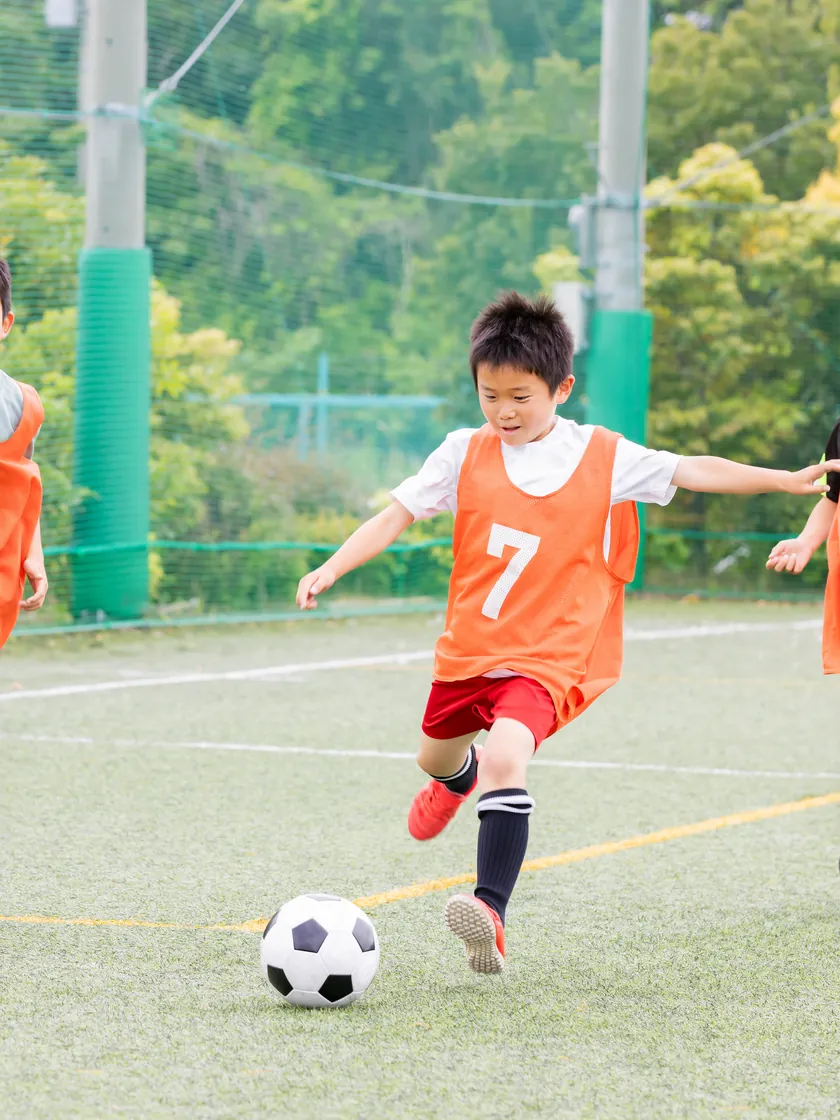 ボールを追って走る子どもたち
